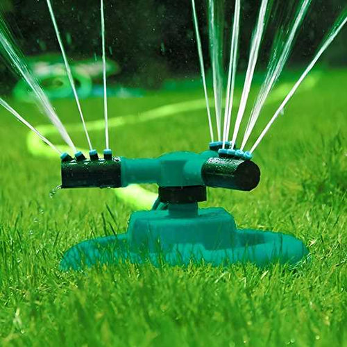 Green lawn sprinkler spraying water on a grassy area
