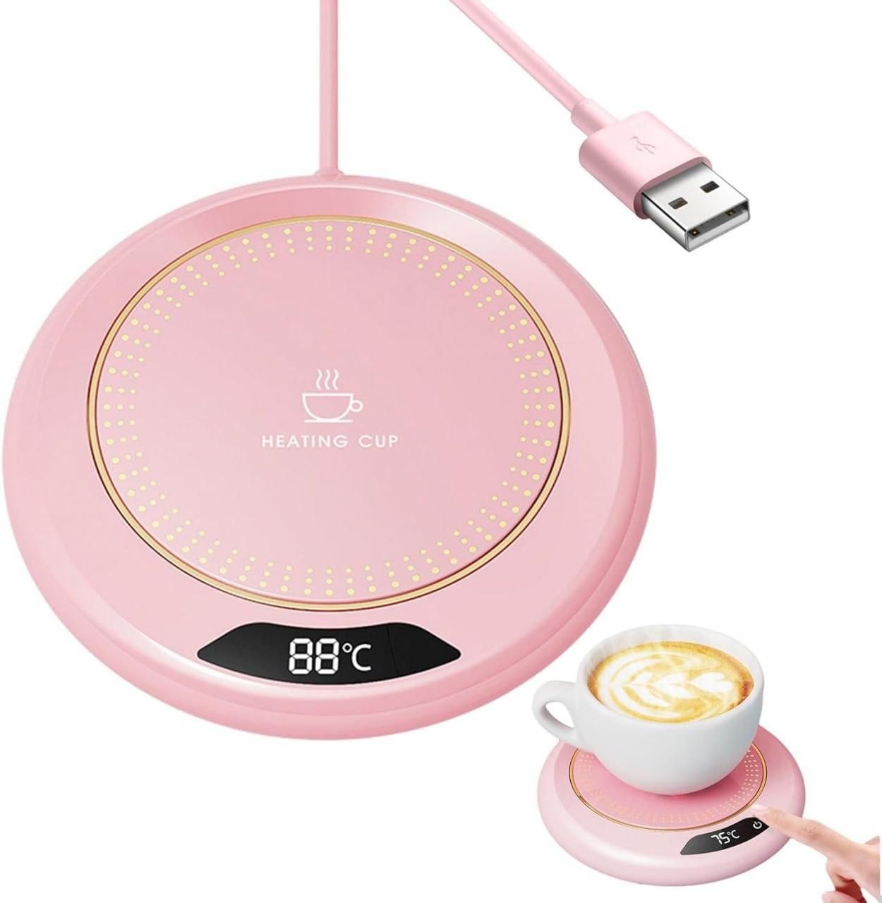Pink heating cup pad with digital display and USB cable, next to a cup of coffee.